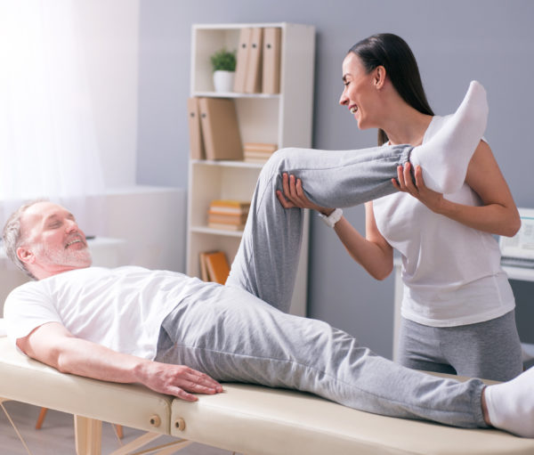 physical therapists working with elderly male patient