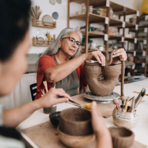 Senior woman making a craft product on a ceramics workshop